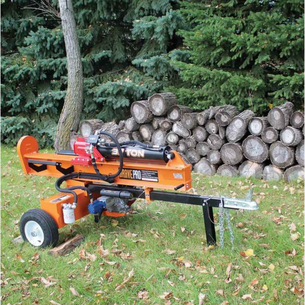 brave pro 37 ton towable Log splitter in a forest setting with stacked logs and trees.