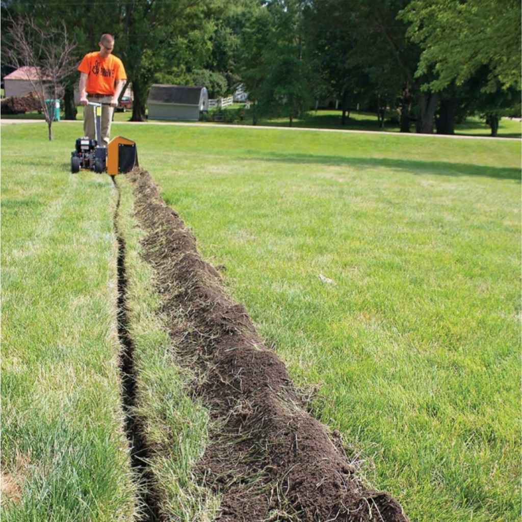 Person using a brave pro 7 inch trencher to dig a trench in a grassy park