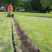 Person using a brave pro 7 inch trencher to dig a trench in a grassy park