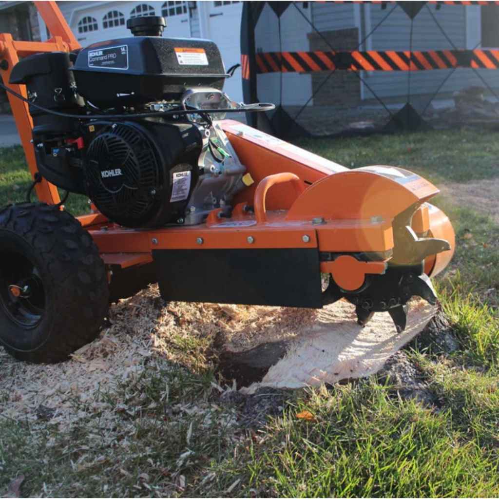 brave 14 hp Stump grinder in use on a stump with grass and a building in the background