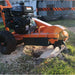brave 14 hp Stump grinder in use on a stump with grass and a building in the background