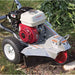 Dosko 200 series mini Stump grinder on a grassy area with a bush in the background