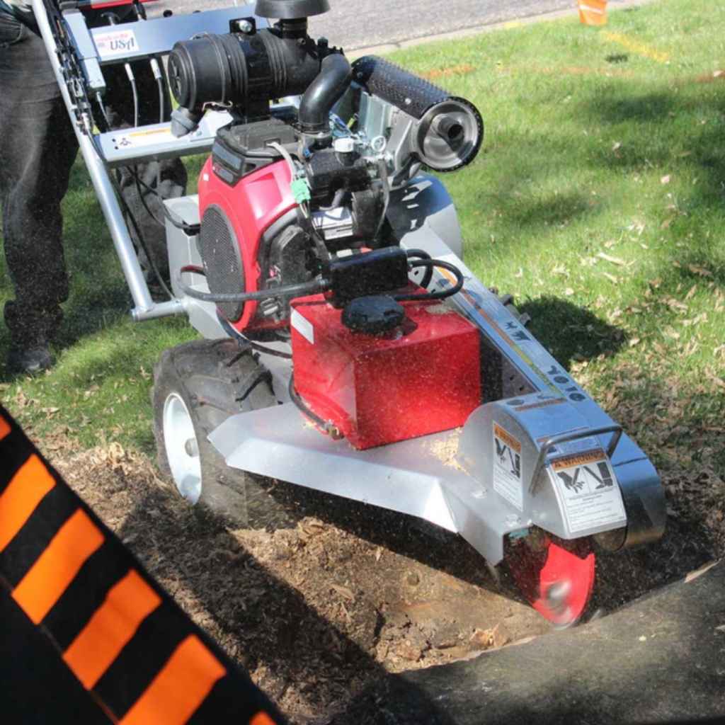 dosko self propelled Stump grinder in use on a grassy area with a person partially visible.