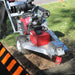 dosko self propelled Stump grinder in use on a grassy area with a person partially visible.