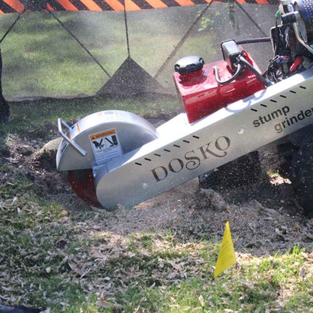 Dosko self propelled 20 hp stump grinder in use on a grassy area with a yellow flag.
