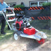 Person operating a dosko self propelled stump grinder in a backyard setting