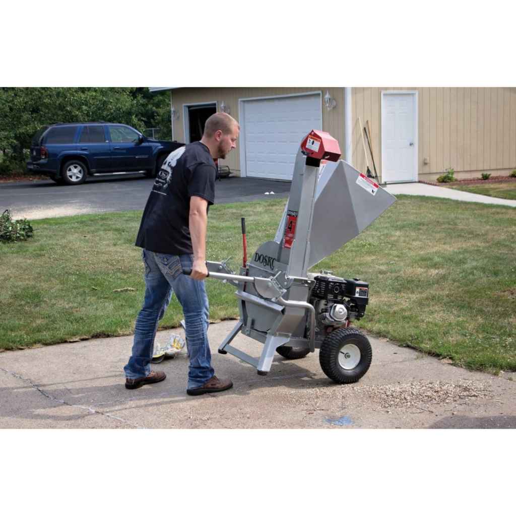 Man operating a dosko portable brush chipper on a driveway