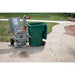 Dosko 4 in brush chipper next to a green trash bin on a sidewalk