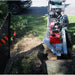 dosko self propelled 20 hp Stump grinder in use on a tree stump with a vehicle and grass in the background.