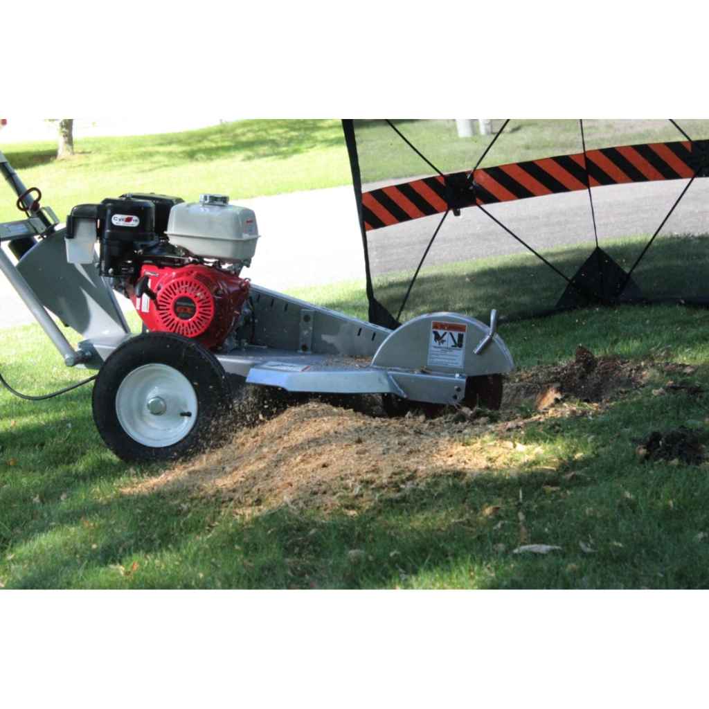 dosko walk behind stump grinder 13 hp being used on grass with a red and black striped barrier in the background