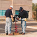 Two men using a groundhog c715 in front of a building.