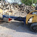 a blue and red iron and oak 24 ton skid mount log splitter attached to a yellow skid loader with logs in the background 