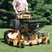 Person operating a Jrco Broadcast spreader 504 cable control on grass with trees in the background