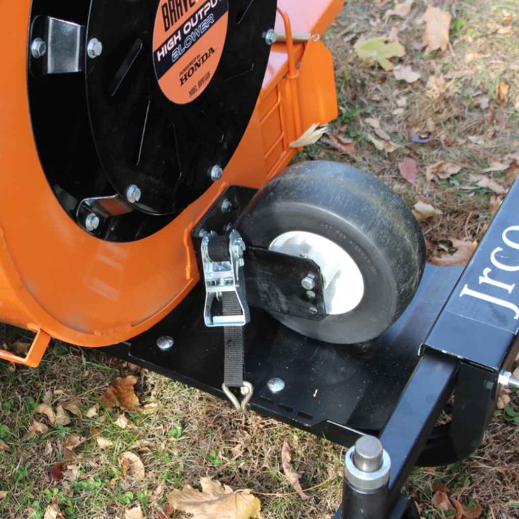 Close-up of a lawn mower with a jrco blower buggy front mount attached with 'Jrco' branding on a grassy background