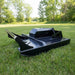 a black loflin skid steer fabtech brush cutter on a grass field side view