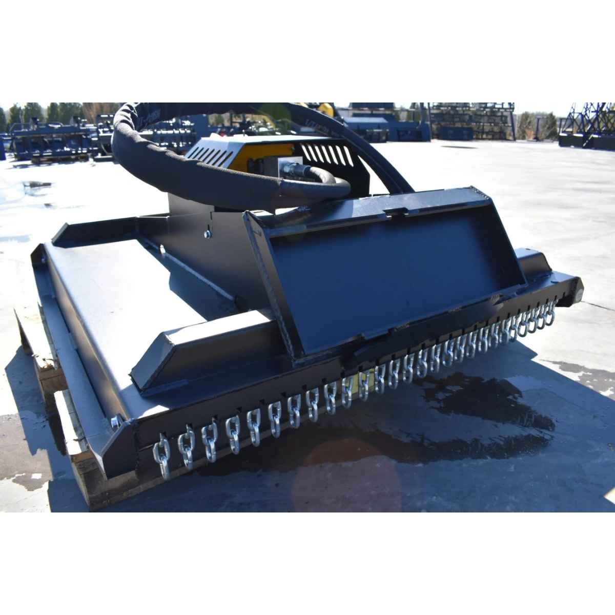 A Black loflin fabrication closed front brush cutter with multiple hanging silver steel chains along the front edge, photographed outdoors on a concrete lot.
