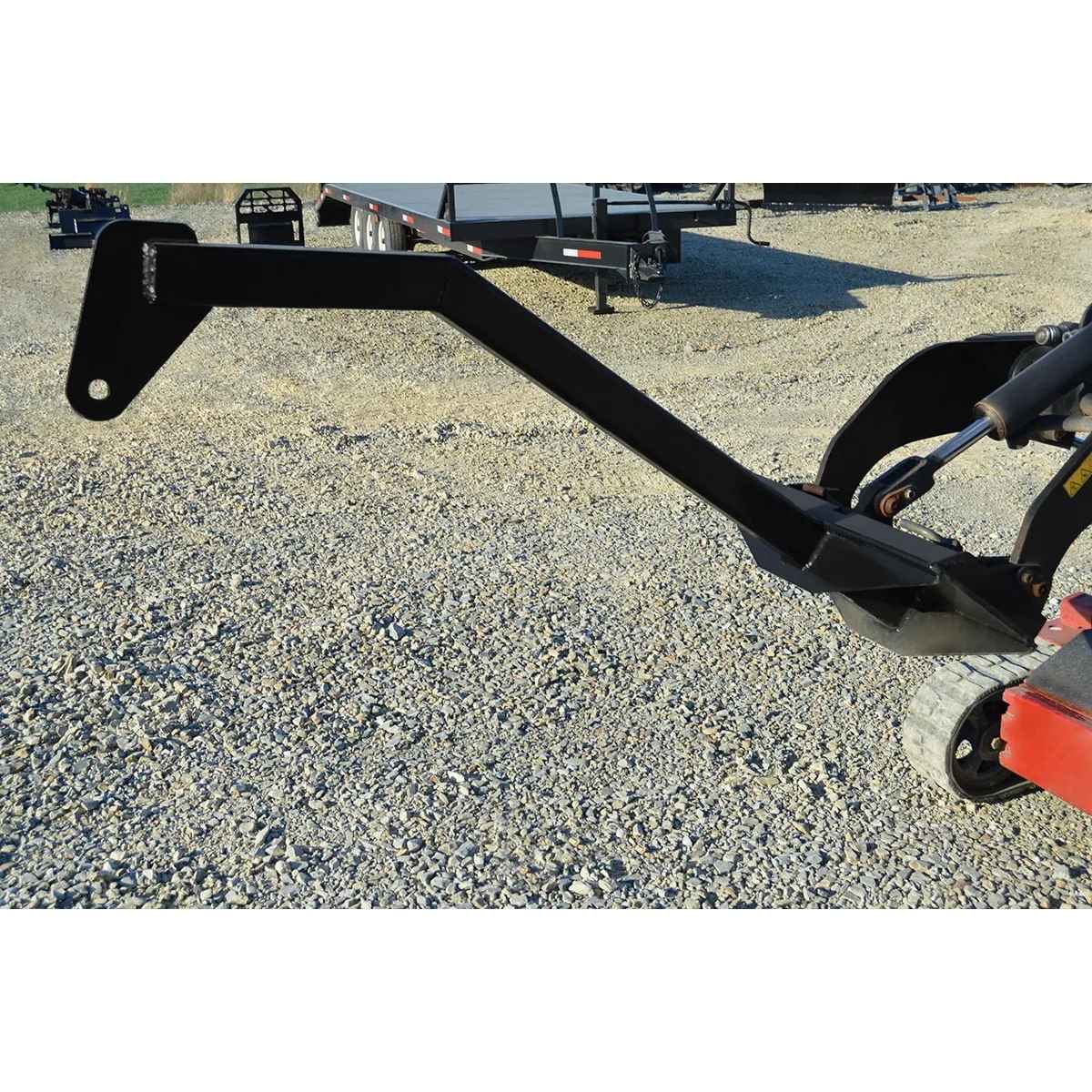 loflin mini skid steer tree boom on a gravel surface with a blurred background