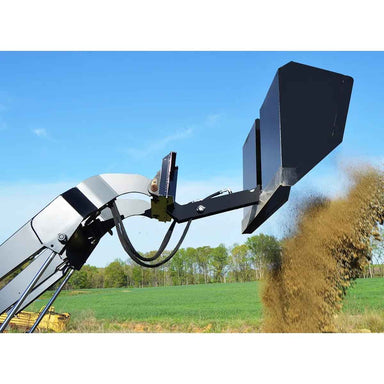 Loflin Fabrication mini front dump bucket discharging material into a field with a clear blue sky.