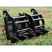 Black Loflin mini skid steer vertical root grapple on a grassy field