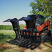red track loader with a black loflin root grapple for sale with open doors in a grassy field
