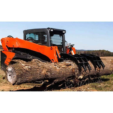 Skid steer loader with a loflin fabrication vertical root grapple holding a large log on a clear day