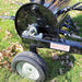 Close-up of a black Maxim 36 inch aerator tow behind with the 'MAXIM' branding on the side of aerator that is on grass with leaves.