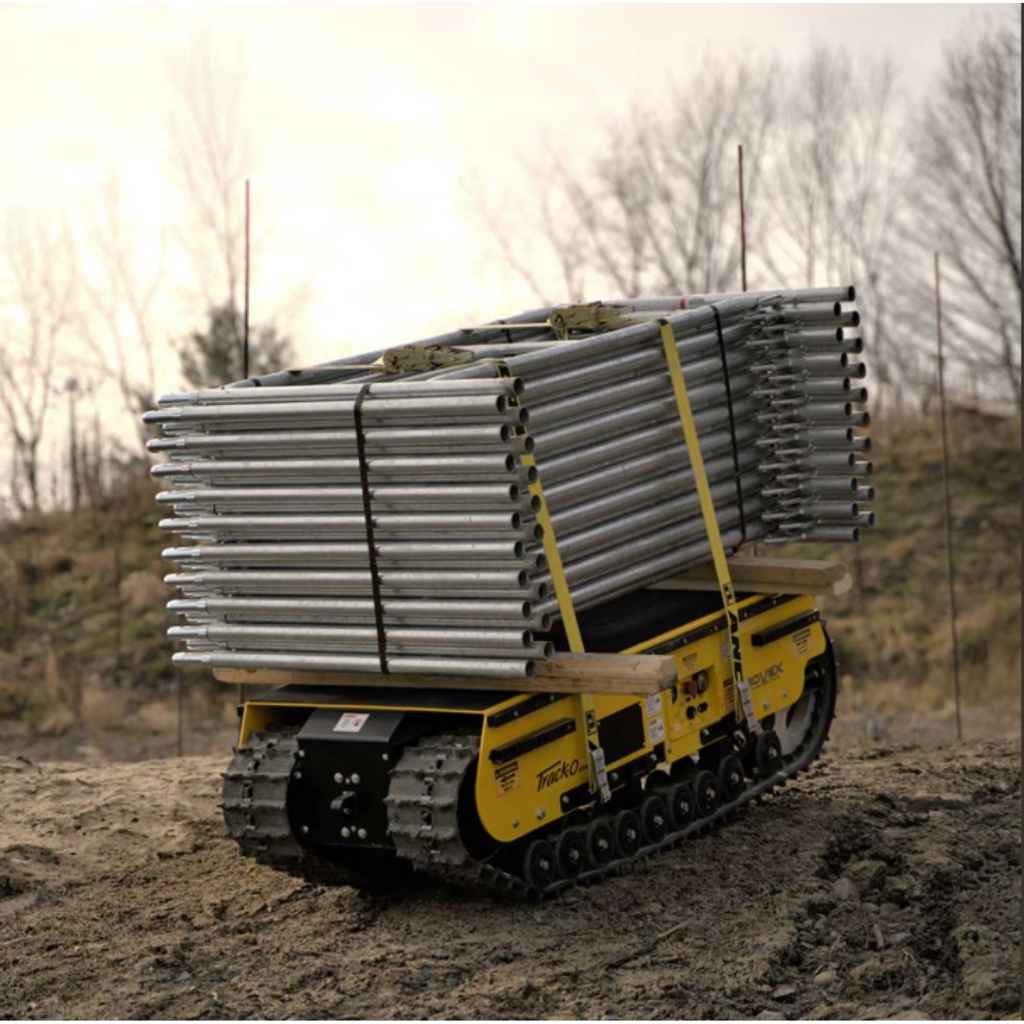 movex cross country vehicle xc 30 carrying a stack of metal pipes on a dirt path with trees in the background