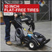 Person using a Northstar 230v 3000 psi pressure washer with text about 10-inch flat-free tires.