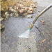 northstar 2000 psi electric pressure washer cleaning a concrete surface with leaves and debris.
