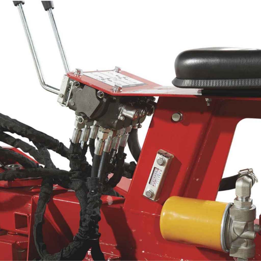 Close-up of a red nortrac towable backhoe trencher with mechanical components and black cables.