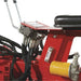 Close-up of a red nortrac towable backhoe trencher with mechanical components and black cables.