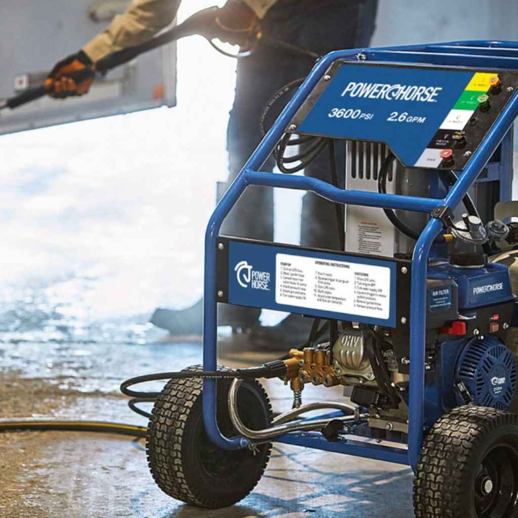 Powerhorse 3600 psi hot water pressure washer with 'Powerhorse' branding being used on a concrete surface.