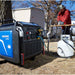 powerhorse 10500 watt inverter generator with a person using a chainsaw in an outdoor setting