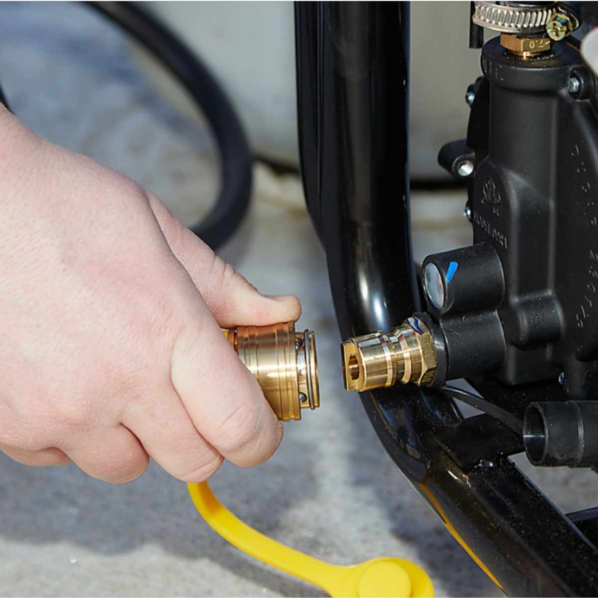 Hand connecting a brass fitting to a powerhorse 12500 generator.