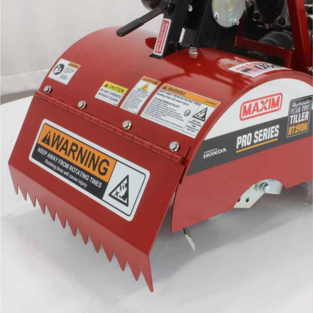 Red maxim rear tine tiller with warning labels on a white background