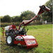 Red Maxim tiller rt190h on a grassy field with trees in the background