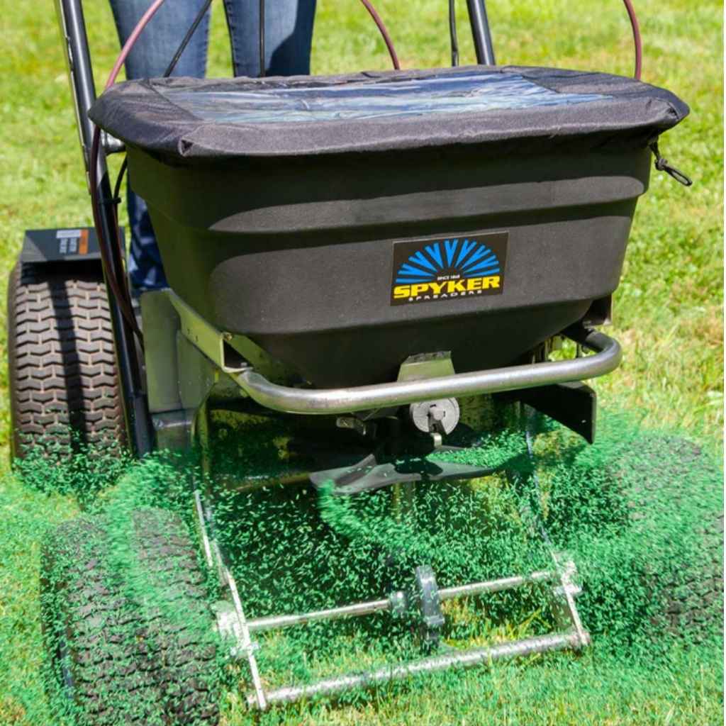 Spyker ride on 120 lbs fertilizer spreader on a grassy area with a person partially visible.
