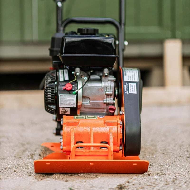 An orange and black plate compactor by superhandy with a gas engine, designed for compacting soil and gravel. Front view outdoors.