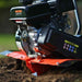 Close-up of a superhandy garden tiller 27 inch engine on a grassy background