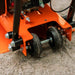 Close-up of an orange superhandy 7hp plate compactor with wheels on a concrete surface