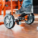 Person using a small orange superhandy material lift with wheels on a wooden floor.