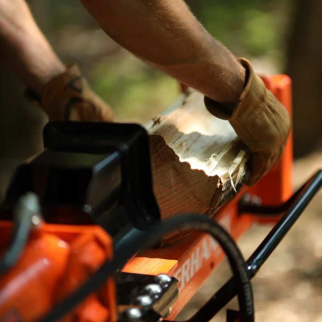 Person using a superhandy gas log splitter 25 ton to cut wood with a blurred natural background