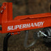An orange and black 14 Ton Electric Log Splitter with a 20 inch max log length. The equipment is corded and has wheels for mobility. Side view outdoors with logo.
