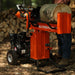 A 25 Ton Gas Log Splitter with a 7HP 209CC engine, colored in orange and black, with a large log placed on its splitting platform. Front view outdoors horizontal position.