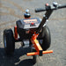 An orange and black SuperHandy 2800 lb electric power Dolly with all-terrain tires, a powerful electric motor, and a height-adjustable hitch. Back view outdoors.