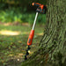 SuperHandy Electric Earth Auger 20v with a 20V 4Ah battery, featuring an orange and black color scheme, with a auger bit inserted vertically. Side view vertical position Outdoors. 20v 