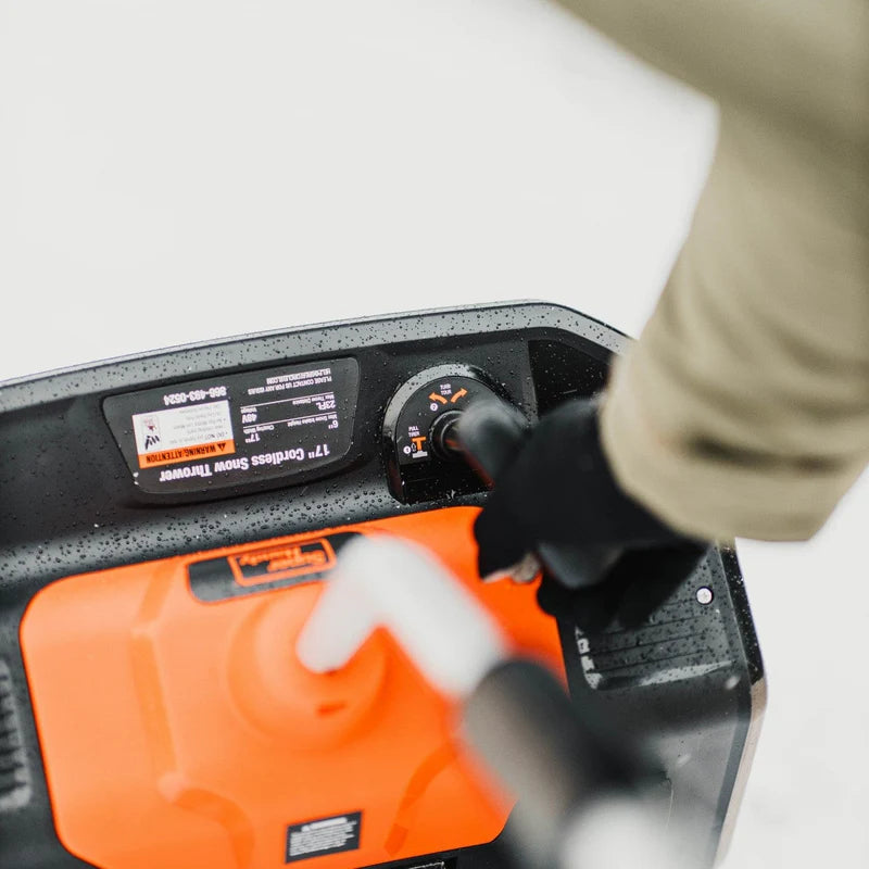 Person using an orange and black SuperHandy Snow Blower Pro with a close-up of the control panel.