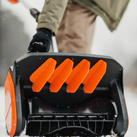 Close-up of a Super Handy snow blower Pro with orange blades, blurred background