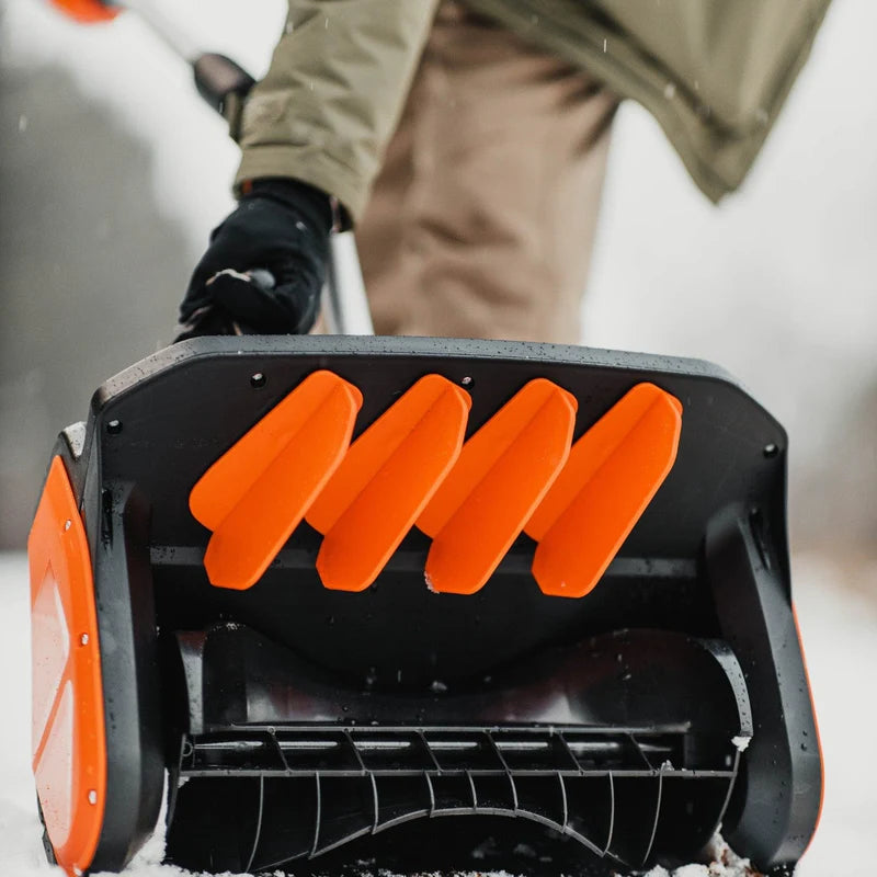Close-up of a Super Handy snow blower Pro with orange blades, blurred background