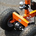 An orange and black electric trailer dolly with four wheels and a control panel. Wheel view outdoors.